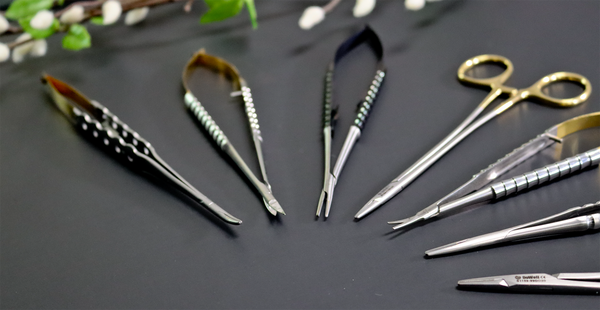 a group of needle holders and scissors